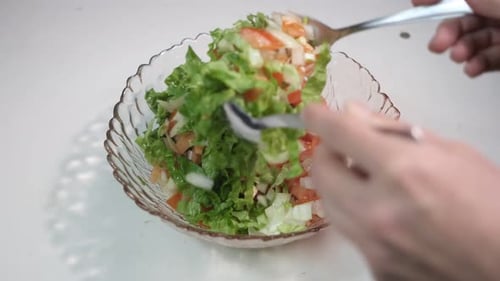 Fresh Salad Mixing in Clear Glass Bowl