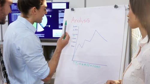 Man Presenting Data Analysis to Coworkers