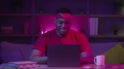Young Adult Uses Laptop at Night in Soft Lighting