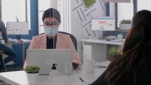 Équipe commerciale avec masques faciaux travaillant chez Marketing Ideas