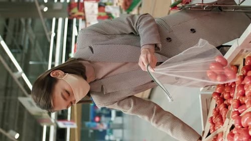 Young Woman Shops for Tomatoes in Supermarket