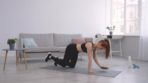 Young Woman Exercising on Yoga Mat at Home