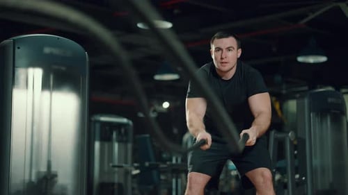 Strong Man Working Out with Battle Ropes in Gym