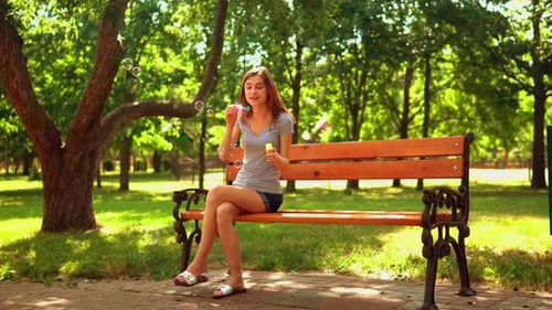 Woman Enjoys Blowing Bubbles in the Park