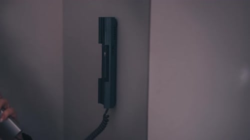 Woman Using Apartment Intercom Receiver