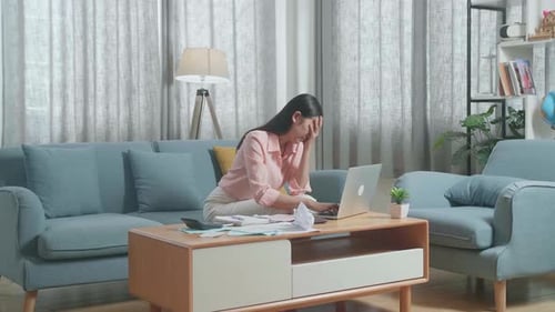 Asian Woman Having A Headache While Working With A Laptop At Home