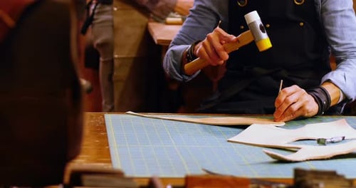 Leather Craftsperson Working with Tools and Hammer