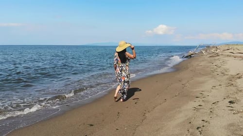 Una mujer camina sola en la playa