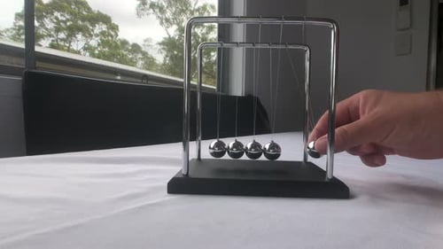 Newton's Cradle Balances Motion and Energy