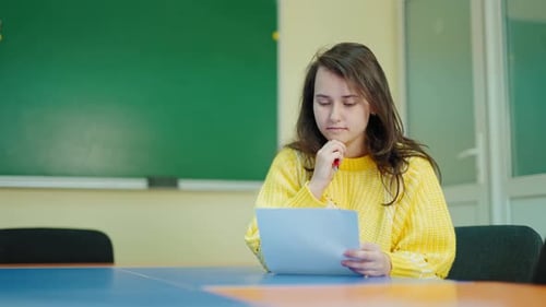 Student Concentrating and Writing in a Classroom