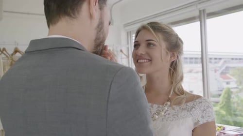Bride and Groom Hold Hands in Bridal Shop