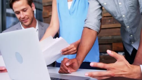 Diverse Team Collaborating on Laptop in Office