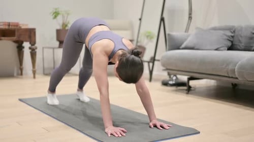 Woman Practicing Yoga on Mat in Living Room
