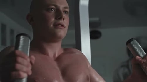 Man Exercising Muscles on Machine at Gym