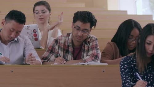 Group of Multicultural Students Taking Notes From Lecture