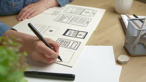 UI designer sketches the user interface of a web application for a mobile phone.