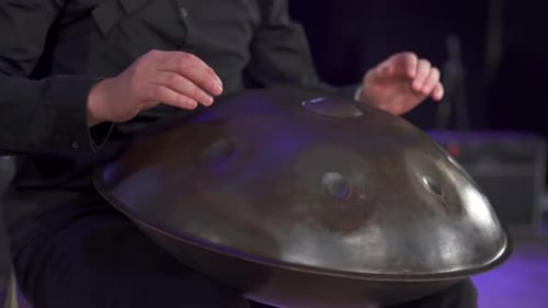 Close Up View of Musician Hands Playing Handpan Drum on Big Concert Hall Stage