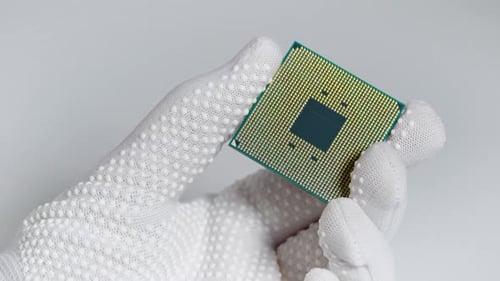 CPU. A Laboratory Technician Holds a Powerful Processor in His Hands. A Group of Scientists Is