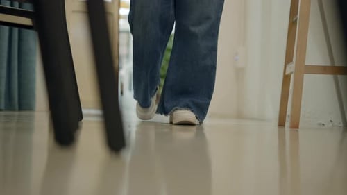 Person Walking Indoors Across Reflective Floor
