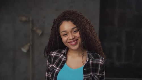 Smiling Woman With Curly Hair Posing Indoors
