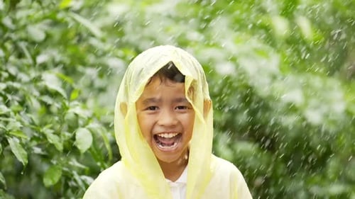 Happy Child Laughing in the Rain Wearing Raincoat