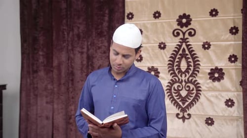 Man Praying Indoors with Book