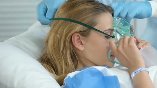 Hospital Nurse Helping Sick Woman to Put on Oxygen Mask, Respiratory Disorder
