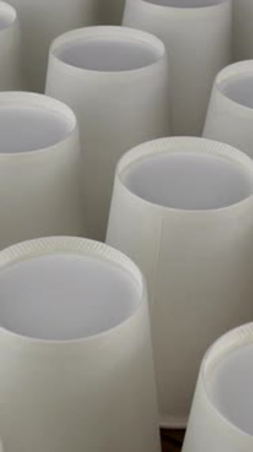 Row of White Disposable Paper Cup for Coffee or Hot Beverage on Dark Backdrop Rotate Slowly