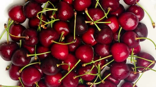 Cherries Rotate on a Plate on a Blue Background