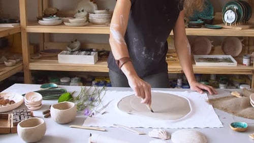 Potter Working on Clay Plate in Studio