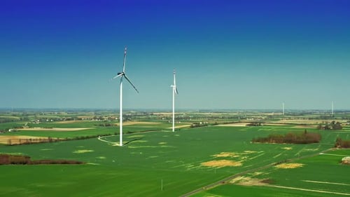 Verbrannte Windturbinen mit blauem Himmel auf einer grünen Wiese, Luftaufnahme