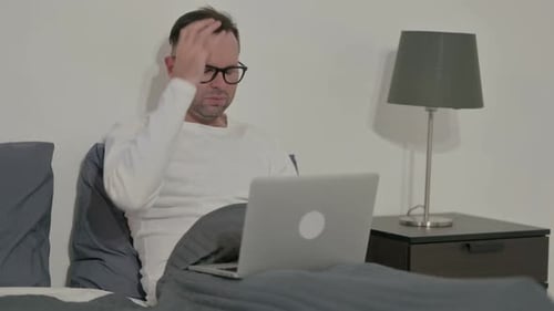 Adult Surprised While Using Laptop Computer in Bed