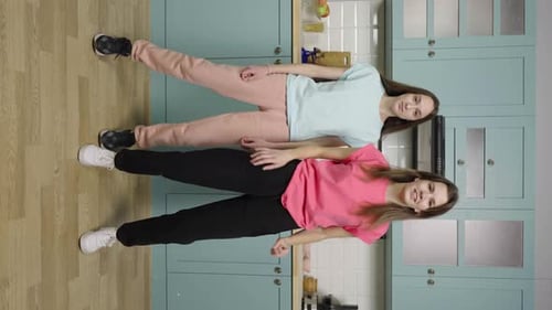 Two Cheerful Women Dancing in Kitchen