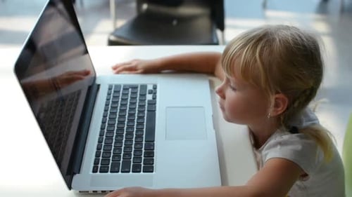 Focused Child Uses Laptop at Table