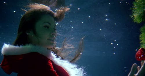 Woman in Santa Suit Underwater with Rose
