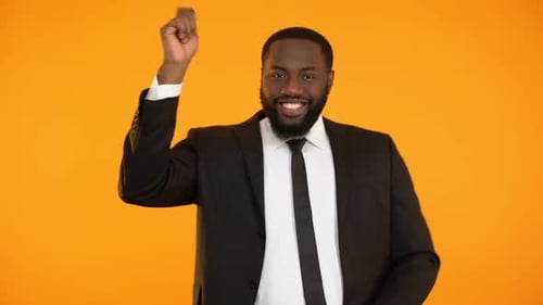 Man in Suit Dances and Smiles on Yellow