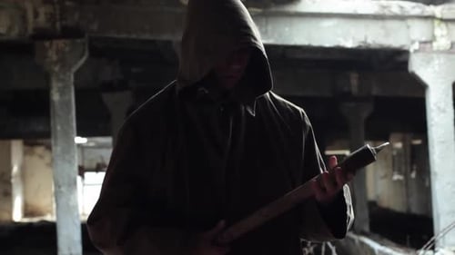 Man in Hooded Coat Holds Axe in Ruins