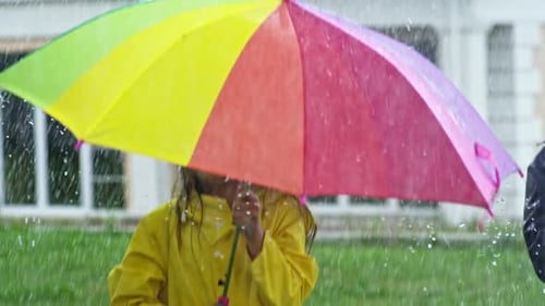 Giggling Children Jumping in Rain
