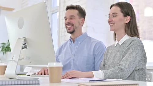 Smiling Man and Woman Working on Computer