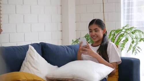 Woman Relaxing on Couch Using Cell Phone