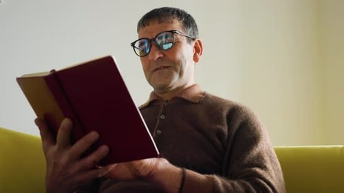 Mature Man Reading Book at Home