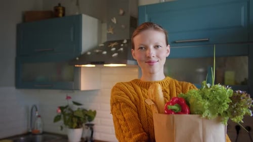 Young Woman Holding Fresh Vegetables in Kitchen