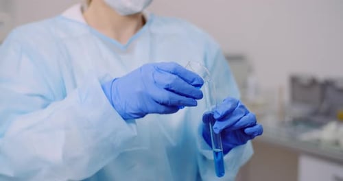 Female Scientist Holding Tubes and Flask with Liquid in Hands