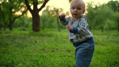 Little Baby Walking in Green Forest. Close Up of Adorable Toddler Outdoors