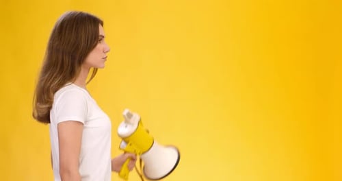 Woman Speaking into Megaphone on Yellow Background