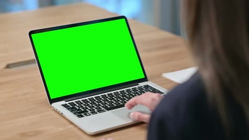 Rear View of Businesswoman using Laptop with Green Chroma Key Screen