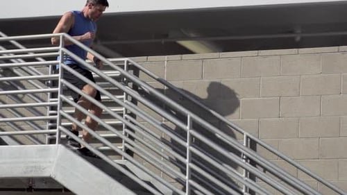 Man Running Down Stairs Outside in Daytime