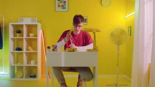 Young Adult Using Rotary Phone in Yellow Room