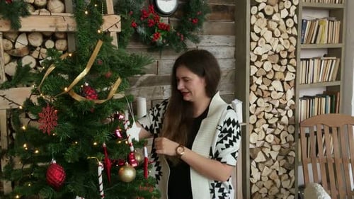 Woman Decorating Christmas Tree with Festive Ornaments