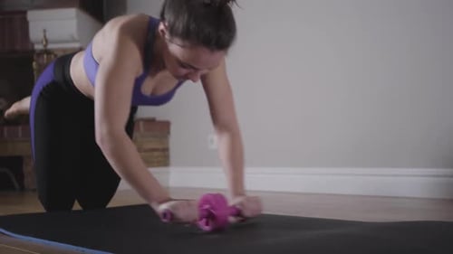 Beautiful Slim Woman Training with Rolling Wheel. Workout of Young Caucasian Brunette Girl in Sport